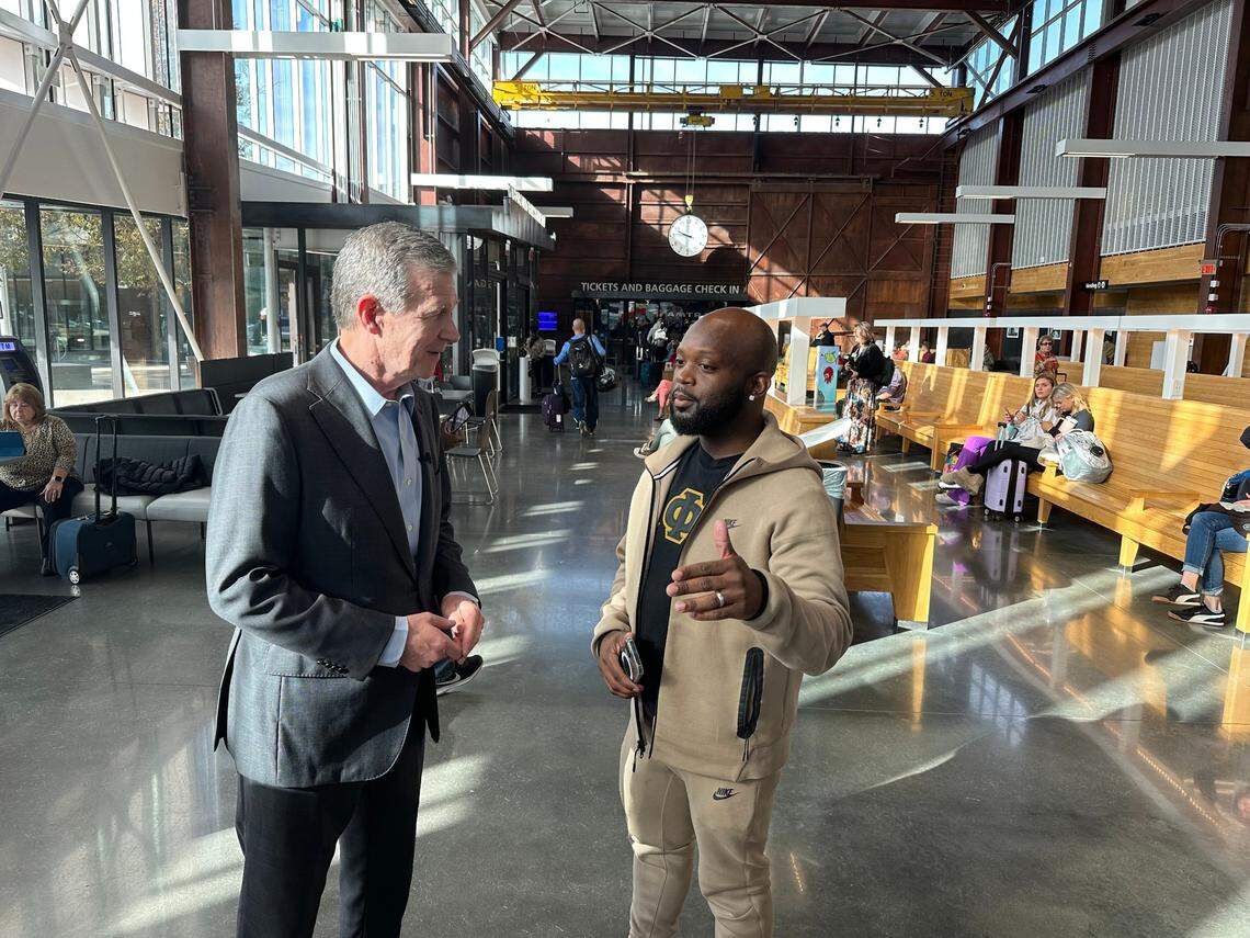 N.C. Gov. Roy Cooper, left, talks with Montravias King of Charlotte before both of them boarded the Piedmont train at Raleigh Union Station on Friday, Nov. 17.
