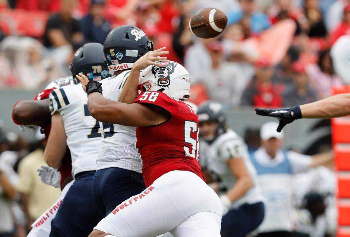 N.C. State defensive end Travali Price (58) hits Charleston Southern quarterback Ross Malmgren (5) as he throws during the first half of N.C. States game against Charleston Southern at Carter-Finley Stadium in Raleigh, N.C., Saturday, Sept. 10, 2022.