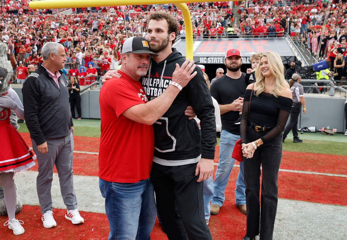 Former N.C. State linebacker Payton Wilson hugs his father Chad during a ceremony where Wilson was inducted into the Ring of Honor during the Wolfpack’s game against Stanford at Carter-Finley Stadium in Raleigh, N.C., Saturday, Nov. 2, 2024.