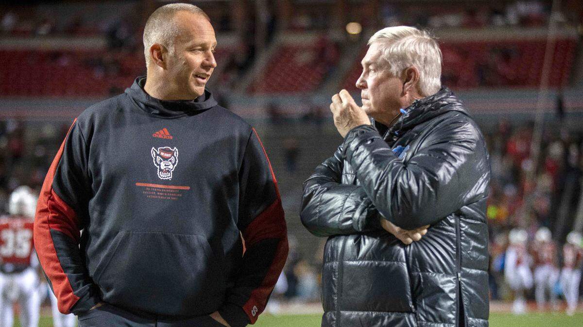 N.C. State coach Dave Doeren talks with North Carolina coach Mack Brown prior to their game on Friday, November 26, 2021 at Carter-Finley Stadium in Raleigh, N.C.