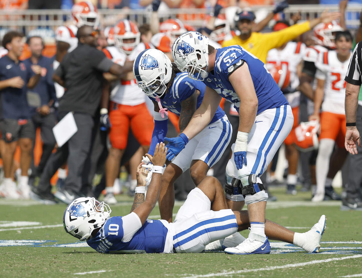 Duke’s Andrel Anthony and Brian Parker II help up teammate Darian Mensah during the second half of the Blue Devils’ 45-19 loss to Illinois on Saturday, Sept. 6, 2025, at Wallace Wade Stadium in Durham, N.C.