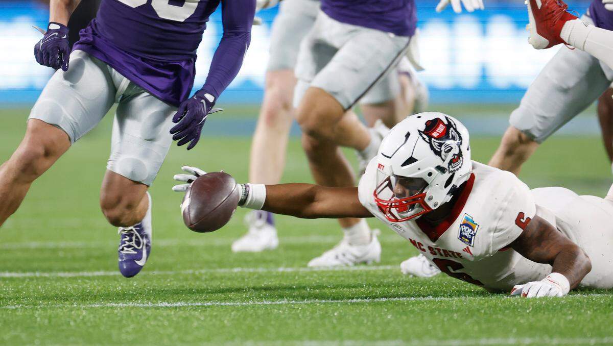 N.C. State’s Trent Pennix (6) can’t pull in the loose ball after Kansas State fumbled a punt during the first half of N.C. State’s game against Kansas State in the Pop-Tarts Bowl at Camping World Stadium in Orlando, Fla., Thursday, Dec. 28, 2023.