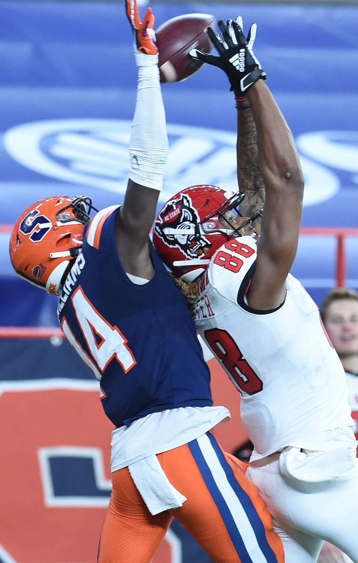 Syracuse Orange defensive back Garrett Williams (14) and North Carolina State Wolfpack wide receiver Devin Carter (88) reach for a pass in the second half on Saturday, Nov. 28, 2020, at the Carrier Dome in Syracuse, N.Y.
