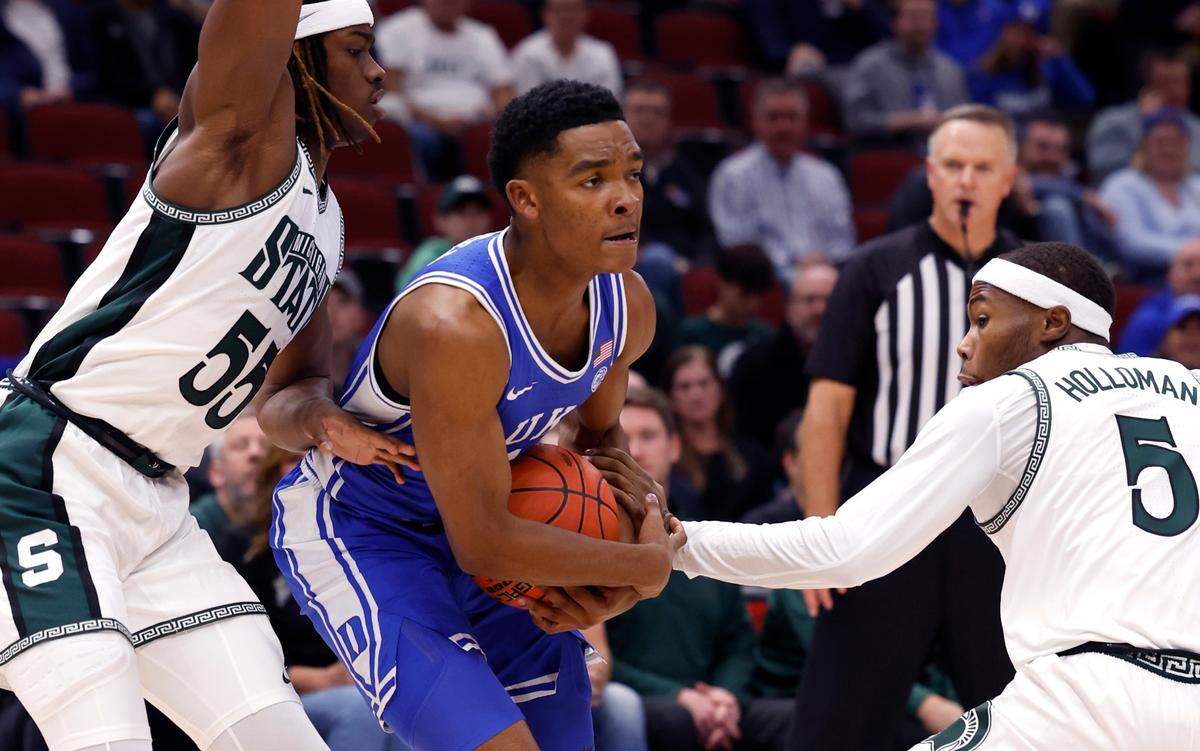 Duke’s Caleb Foster (1) drives by Michigan State’s Coen Carr (55) and Jeremy Fears Jr. (1) during the first half of Duke’s game against Michigan State in the Champions Classic at the United Center in Chicago, IL, Tuesday, Nov. 14, 2023.
