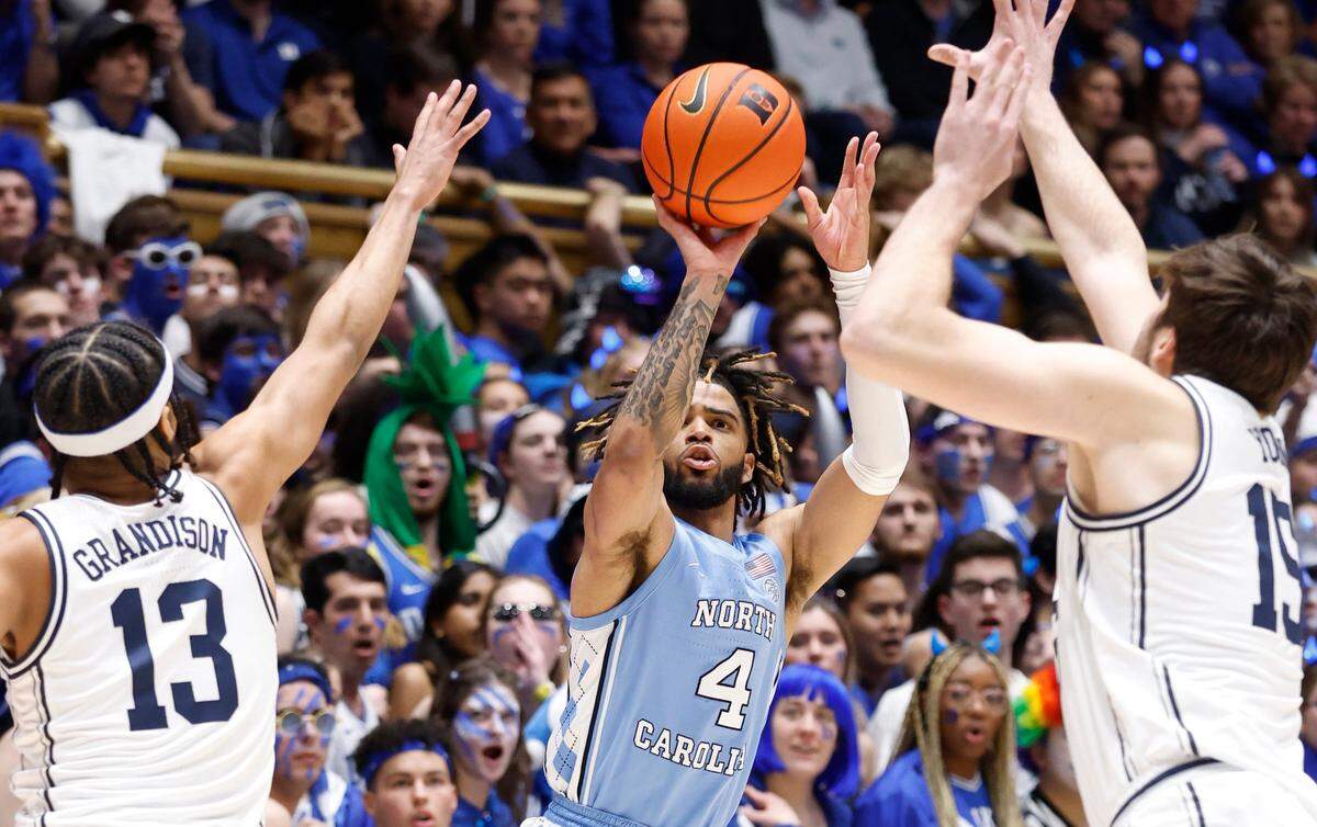 North Carolina’s R.J. Davis (4) shoots as Duke’s Jacob Grandison (13) and Ryan Young (15) defend during the first half of Duke’s game against UNC at Cameron Indoor Stadium in Durham, N.C., Saturday, Feb. 4, 2023.