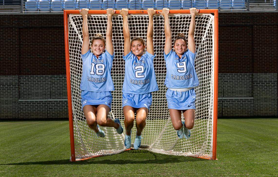 From left North Carolina lacrosse sisters Ashley Humphrey (18), Chloe Humphrey (2) and Nicole Humphrey (9) pose at Dorrance Field on the campus of UNC Friday, May 2, 2025.