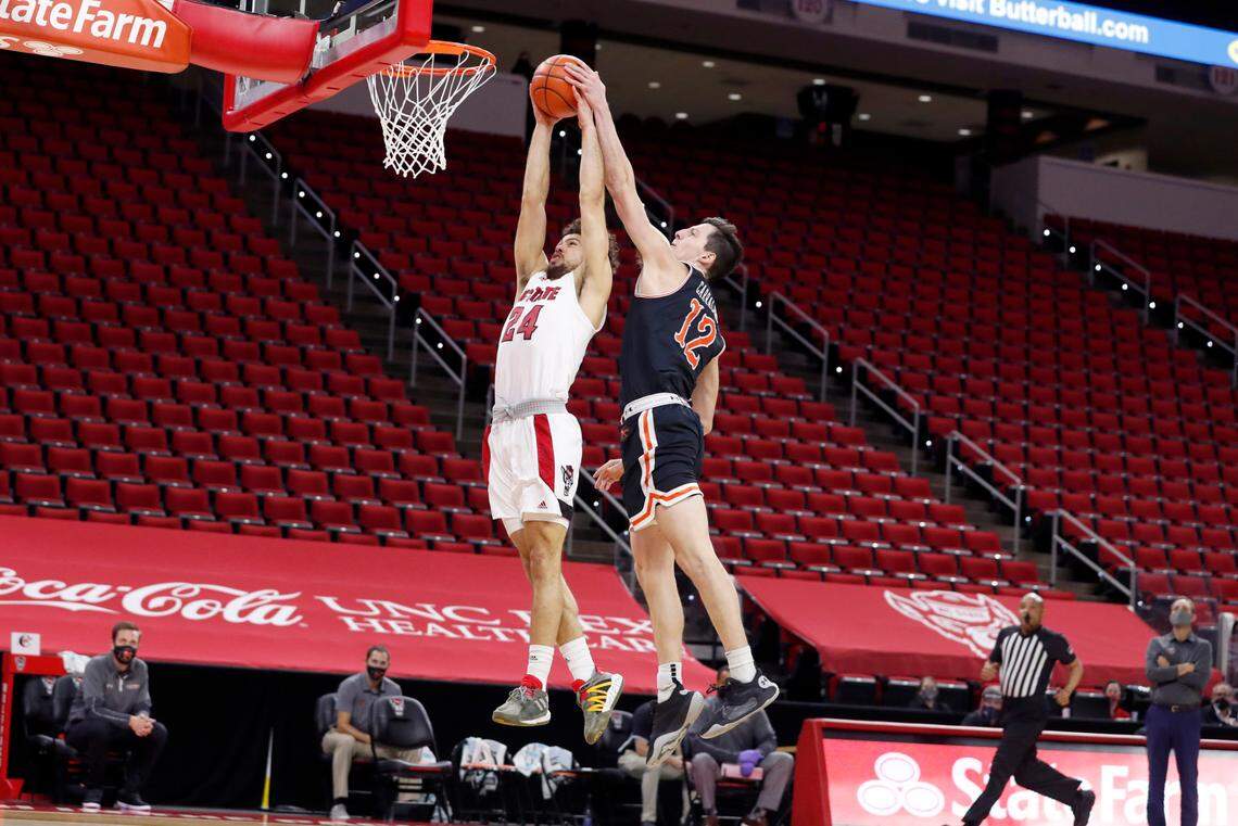 Campbell’s Jesus Carralero (12) blocks the shot by N.C. State’s Devon Daniels (24) during the first half of N.C. State’s game against Campbell at PNC Arena in Raleigh, N.C., Saturday, Dec. 19, 2020.