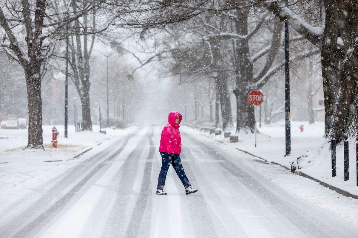 University of North Carolina student Ashton Jarman walks across snow covered Cameron Avenue on campus as a winter storm moves through the area on Wednesday, February 19, 2025 in Chapel Hill, N.C.