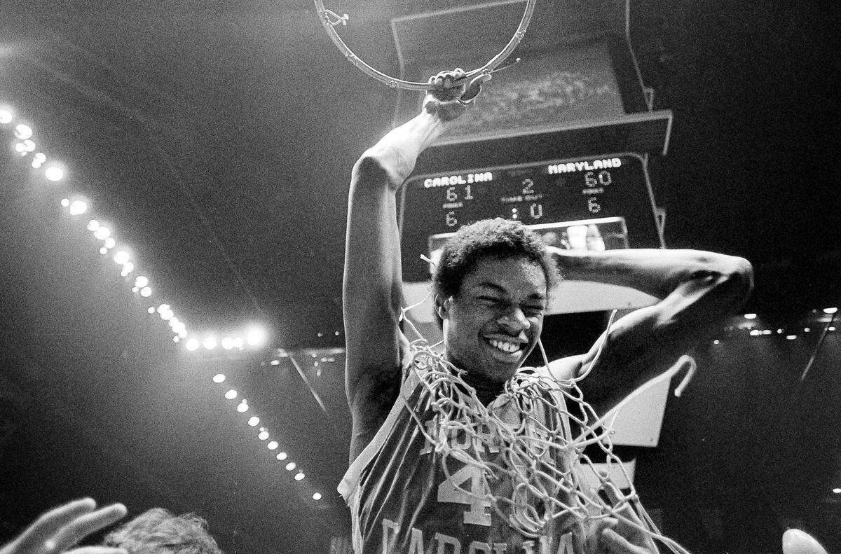 North Carolina’s most valuable player, Sam Perkins, holds onto the rim of the basket after cutting off the net following the Tar Heels victory over Maryland for the ACC tourney championship in Landover, Md., March 8, 1981. North Carolina won, 61-60, and Perkins was named MVP. (AP Photo)