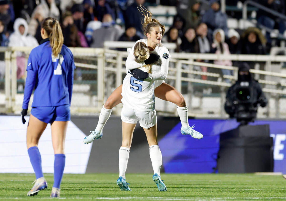 North Carolina’s Kate Faasse (13) jumps into the arms of Maddie Dahlien (5) after Faasse scored on a penalty kick during the first half of UNC’s game against Duke in the semifinals of the 2024 Women’s College Cup at WakeMed Soccer Park in Cary, N.C., Friday, Dec. 6, 2024.