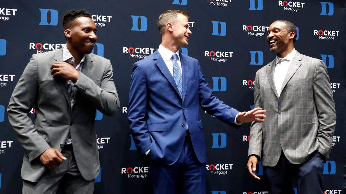 Jon Scheyer, center, laughs with associate head coach Chris Carrawell, right, and assistant coach Nolan Smith after Scheyer was introduced as Duke basketball’s 20th head coach at Cameron Indoor Stadium in Durham, N.C., Friday, June 4, 2021.