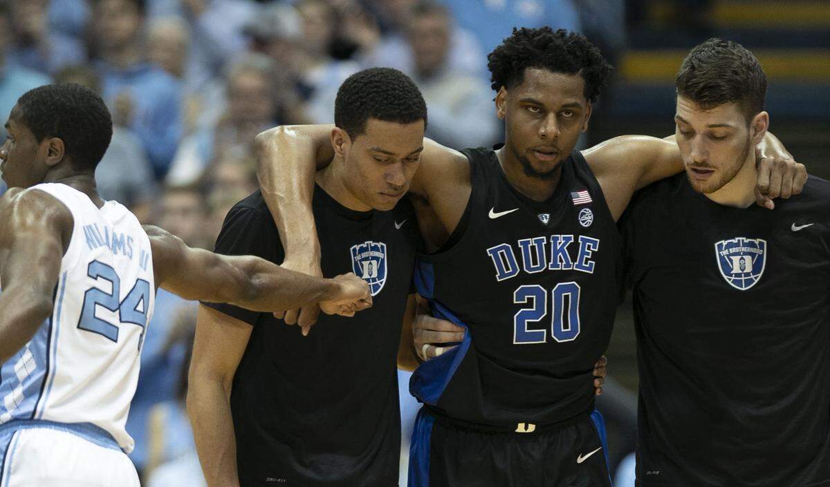Duke’s Marques Bolden (20) is escored off the court after an injury in the first half against North Carolina on Saturday, March 9, 2019 at the Smith Center in Chapel Hill, N.C. North Carolina’s Kenny Williams (24) offers him some support.