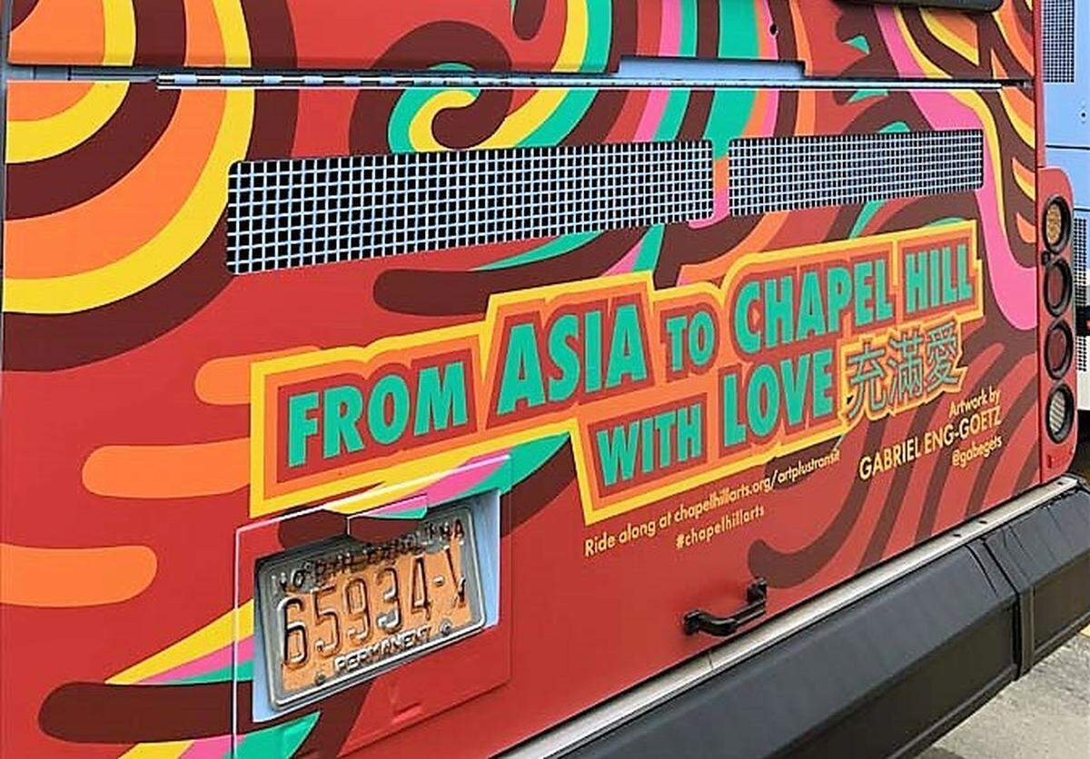 A message to the Chapel Hill-Carrboro community is written in English and Catonese on the back of a Chapel Hill Transit bus. The mobile artwork is part of the town’s Art + Transit beautification program.