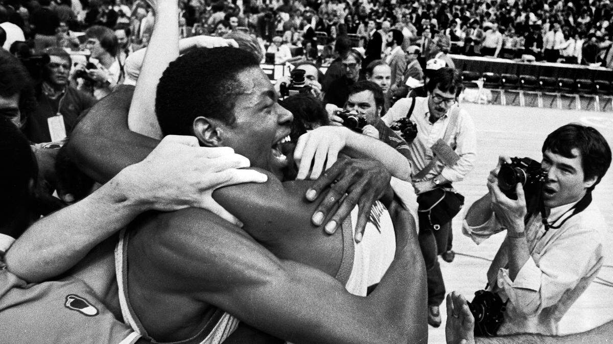UNC center Sam Perkins celebrates with teammates on the floor of the Super Dome after the Tar Heels defeated Georgetown to win the 1982 National Championship.