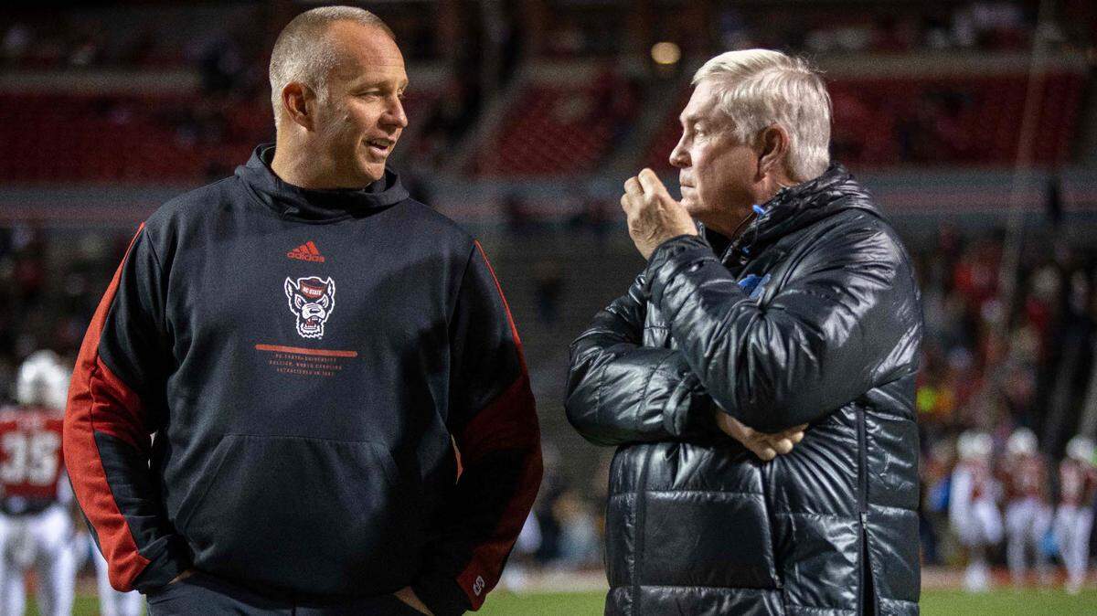 N.C. State coach Dave Doeren talks with North Carolina coach Mack Brown prior to their game on Friday, November 26, 2021 at Carter-Finley Stadium in Raleigh, N.C.