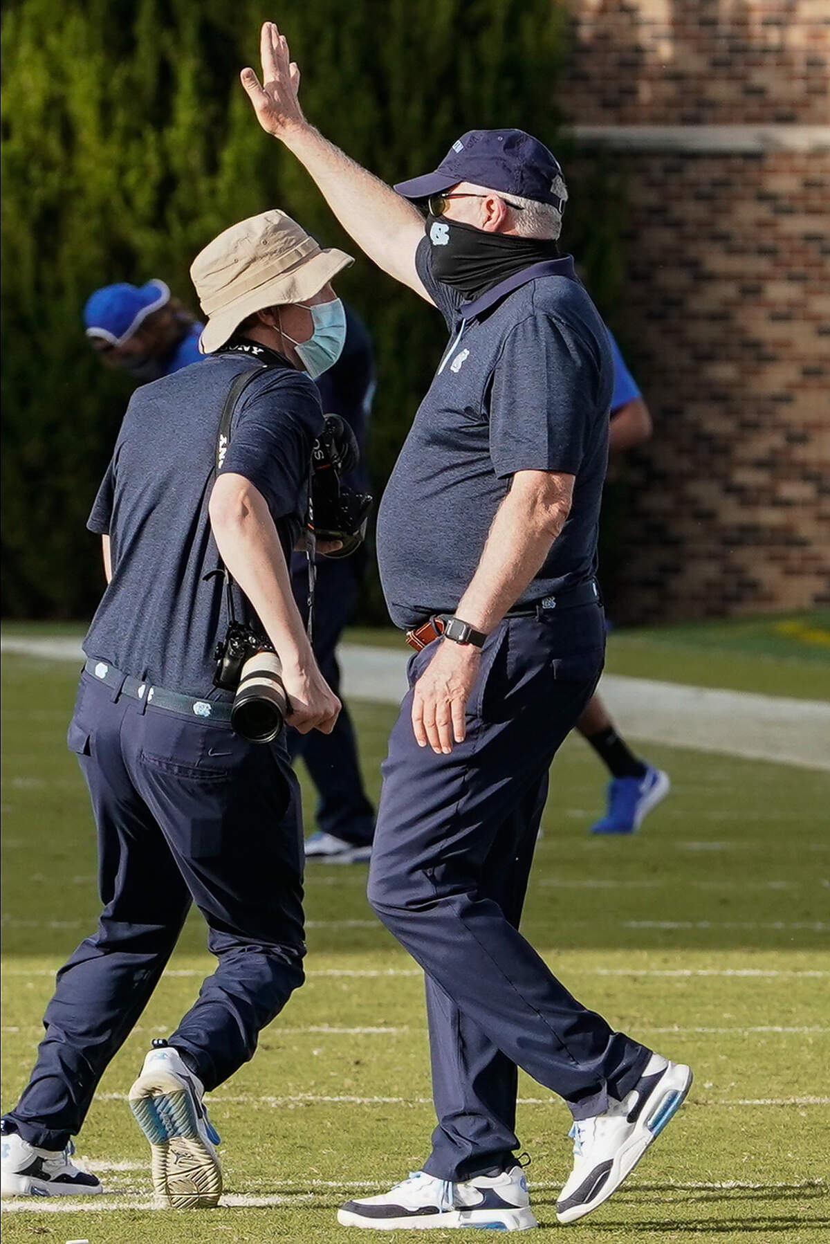 North Carolina Tar Heels head coach Mack Brown waves to Duke Blue Devils head coach David Cutcliffe at the end of the second half at Wallace Wade Stadium. 
