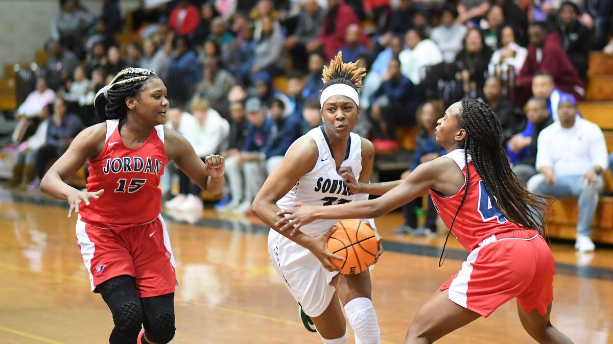 Mikayla Harris, center, of Southeast drives to the basket against Ashaunti Parker (15) and Nia Howard, right, of Jordan. The Jordan Falcons visited the Southeast Bulldogs in a high school girls basketball game on February 29, 2020.