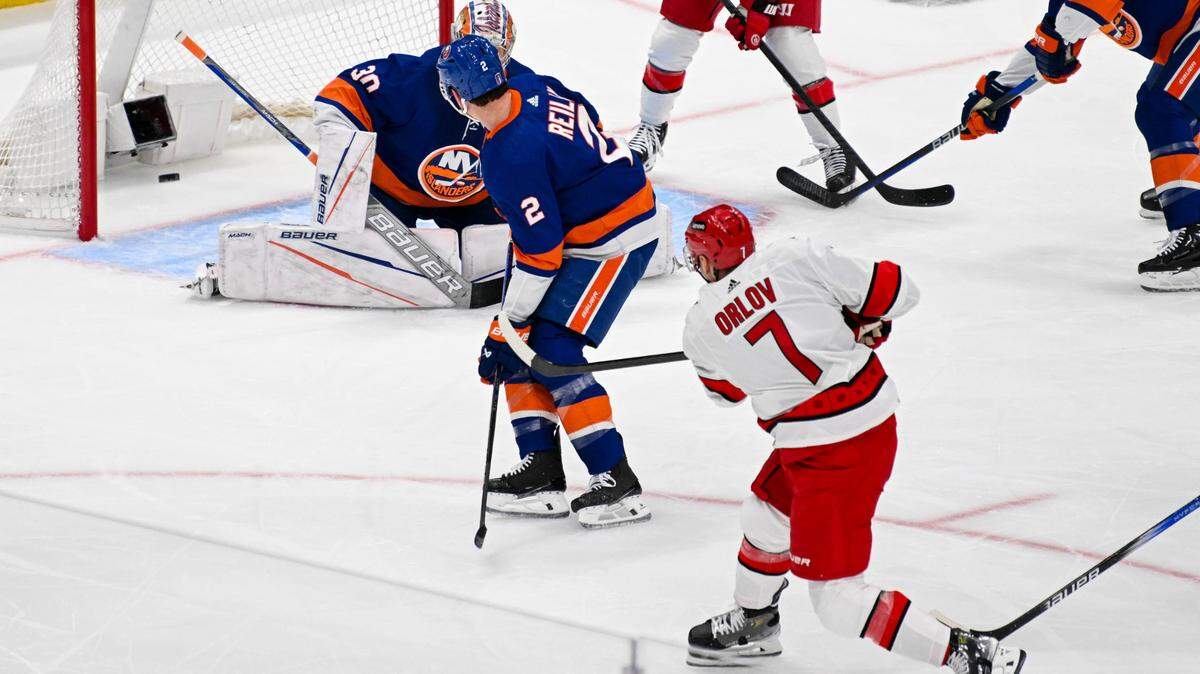 Apr 25, 2024; Elmont, New York, USA; Carolina Hurricanes defenseman Dmitry Orlov (7) shoots and scores a goal past New York Islanders goaltender Ilya Sorokin (30) during the first period in game three of the first round of the 2024 Stanley Cup Playoffs at UBS Arena. Mandatory Credit: Dennis Schneidler-USA TODAY Sports