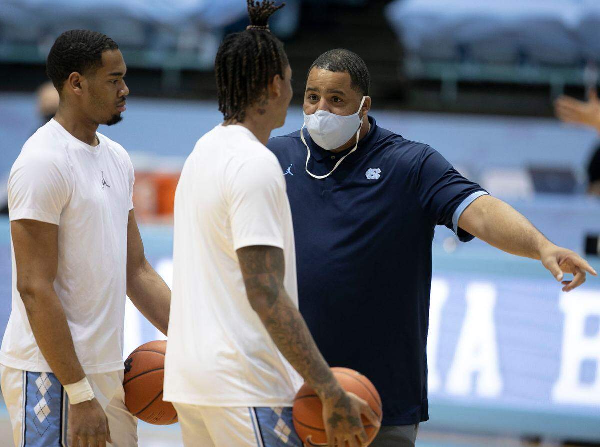 Sean May, North Carolina’s director of operations, talks with Garrison Brooks (15) and Armando Bacot (5) prior to the Tar Heels’ game against Marquette on Wednesday, February 24, 2021 at the Smith Center in Chapel Hill, N.C.