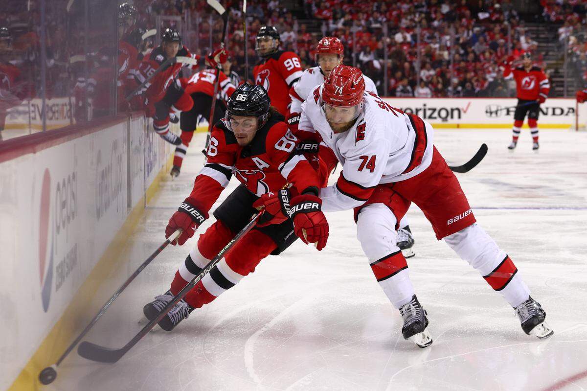 New Jersey Devils center Jack Hughes (86) plays the puck while being defended by Carolina Hurricanes defenseman Jaccob Slavin (74) during the second period in game four of the second round of the 2023 Stanley Cup Playoffs at Prudential Center. 