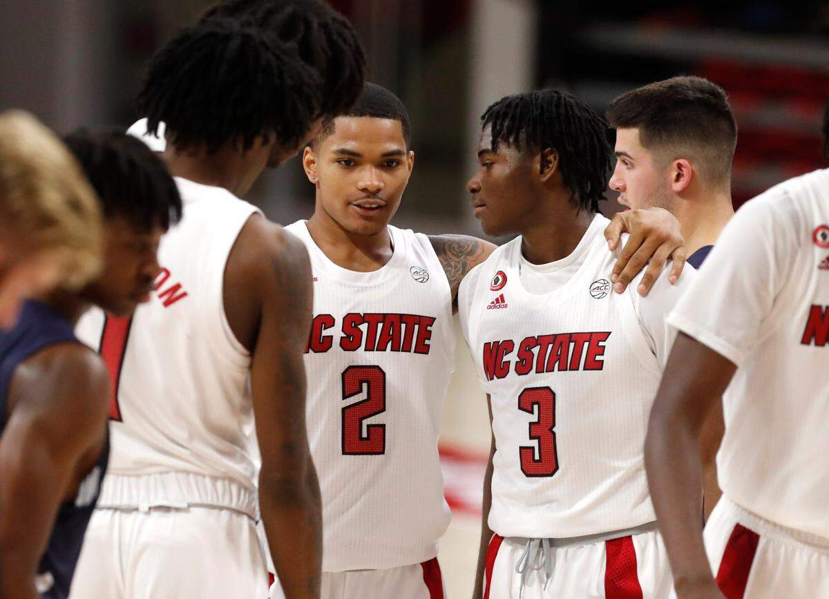 N.C. State’s Shakeel Moore (2), center, talks with Dereon Seabron (1), Jaylon Gibson (11) and Cam Hayes (3) during the second half of N.C. State’s 86-51 victory over North Florida in the Mako Medical Wolfpack Invitational at Reynolds Coliseum in Raleigh, N.C., Friday, Nov. 27, 2020.