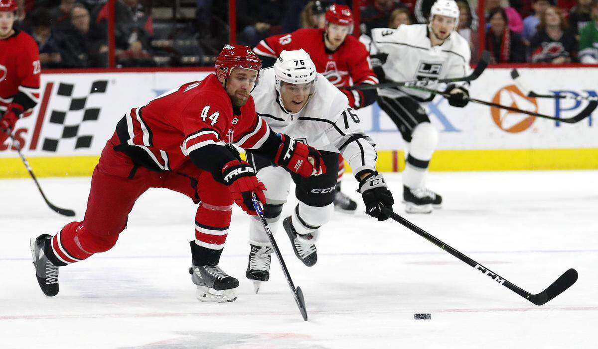 Carolina Hurricanes’ Calvin de Haan (44) and Los Angeles Kings’ Jonny Brodzinski (76) go for the puck during the first period of an NHL hockey game in Raleigh, N.C., Tuesday, Feb. 26, 2019. (AP Photo/Chris Seward)