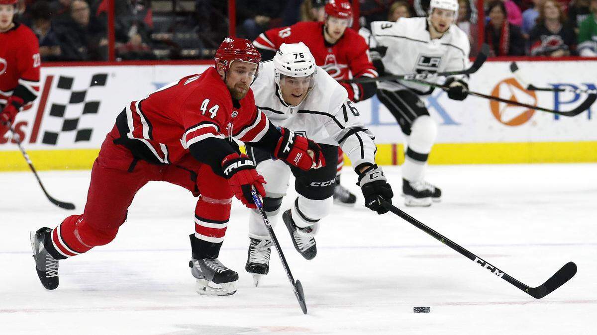 Carolina Hurricanes’ Calvin de Haan (44) and Los Angeles Kings’ Jonny Brodzinski (76) go for the puck during the first period of an NHL hockey game in Raleigh, N.C., Tuesday, Feb. 26, 2019. (AP Photo/Chris Seward)