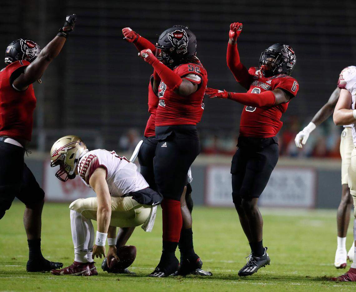 N.C. State’s Isaiah Moore (1), C.J. Clark (52) and Jakeen Harris (6) celebrate stopping Florida State quarterback Chubba Purdy (12) on third down during the first half of N.C. State’s game against Florida State at Carter-Finley Stadium in Raleigh, N.C., Saturday, Nov. 14, 2020.