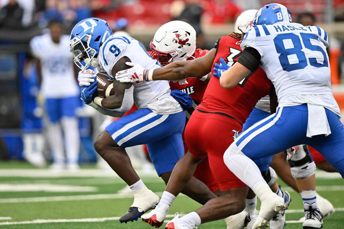 Duke Blue Devils running back Jaquez Moore (9) runs the ball against Louisville Cardinals linebacker TJ Quinn (34) during the second quarter at L&N Federal Credit Union Stadium.