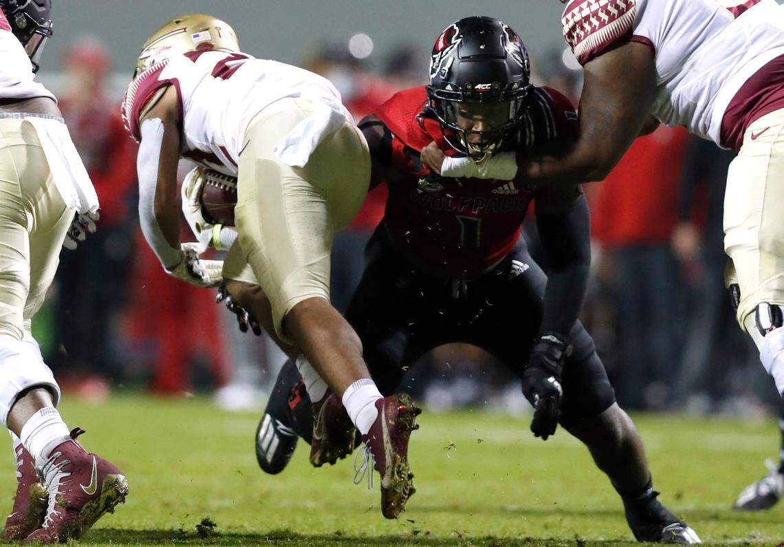 N.C. State linebacker Isaiah Moore (1) tackles Florida State running back Ja’Khi Douglas (22) during the first half of N.C. State’s game against Florida State at Carter-Finley Stadium in Raleigh, N.C., Saturday, Nov. 14, 2020.