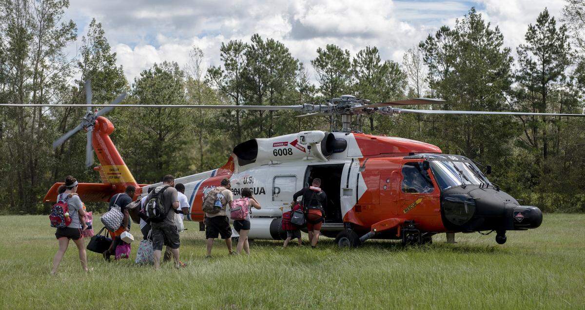 Families board a Coast Guard helicopter in Rocky Point, N.C., Sept. 18, 2018. 