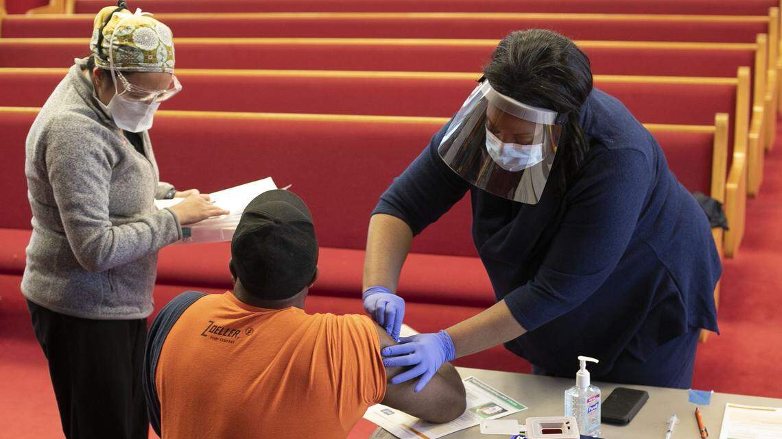 Dr. Nerissa Price, right, prepares to vaccinate Curtis Richardson of Apex, N.C. during a COVID-19 vaccination clinic at New Bethel Christian Church on Saturday, February 6, 2021 in Raleigh, N.C.