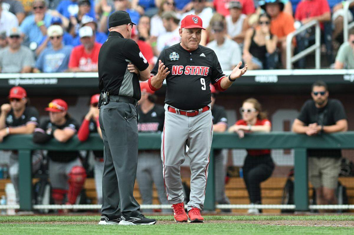 NC State Wolfpack head coach Elliott Avent discusses a balk call with an umpire in the game against the Kentucky Wildcats during the eighth inning at Charles Schwab Filed Omaha.