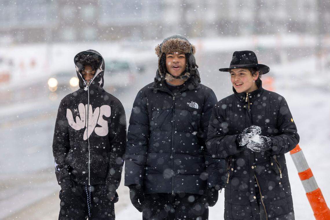 Out of school due to the winter storm, Deveron Colon, Jaylen Poole and Logan Herndon take a walk along Rock Quarry Road as light snow falls on Thursday, February 20, 2025 in Raleigh, N.C.