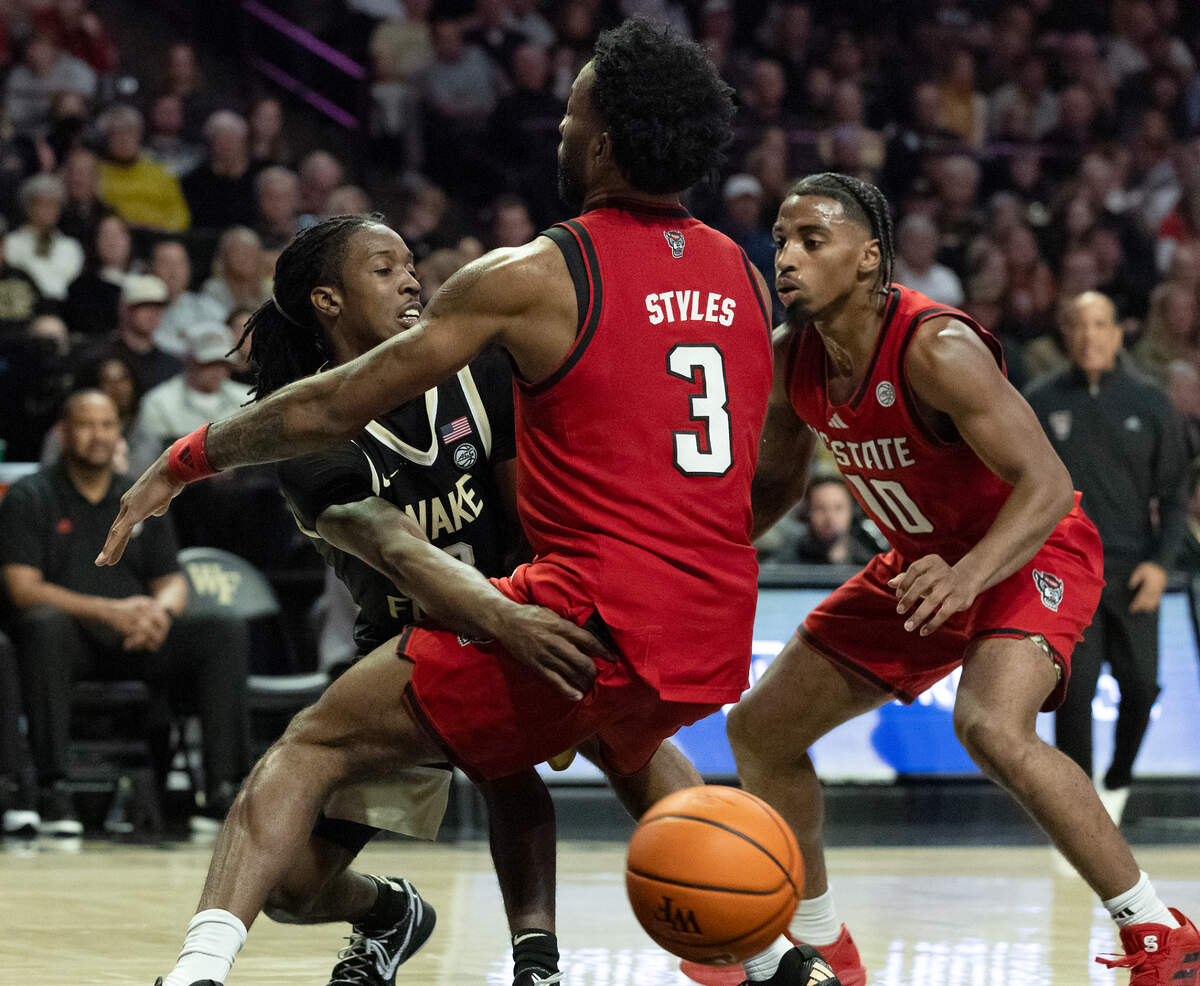 Wake Forest’s Ty-Laur Johnson passes around the defense of N.C. State’s Dontrez Styles and Marcus Hill during the second half of the Wolfpack’s 77-59 loss on Saturday, Jan. 4, 2025, at Lawrence Joel Veterans Memorial Coliseum in Winston-Salem, N.C.