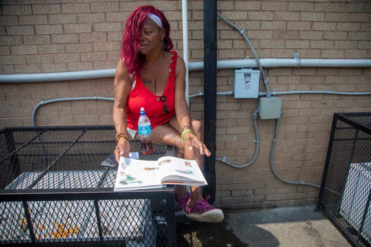Lottie Shelton, a grandmother of 10, sits in an alley way near the Wake Inn in Raleigh where she often stays. Eleven people have been shot at the hotel since January 2020, including one person who died. There have been 832 911-initiated and “self-initiated” calls for police so far this year. Nearly 150 overdoses have been reported at the hotel since 2019, including 34 so far this year.