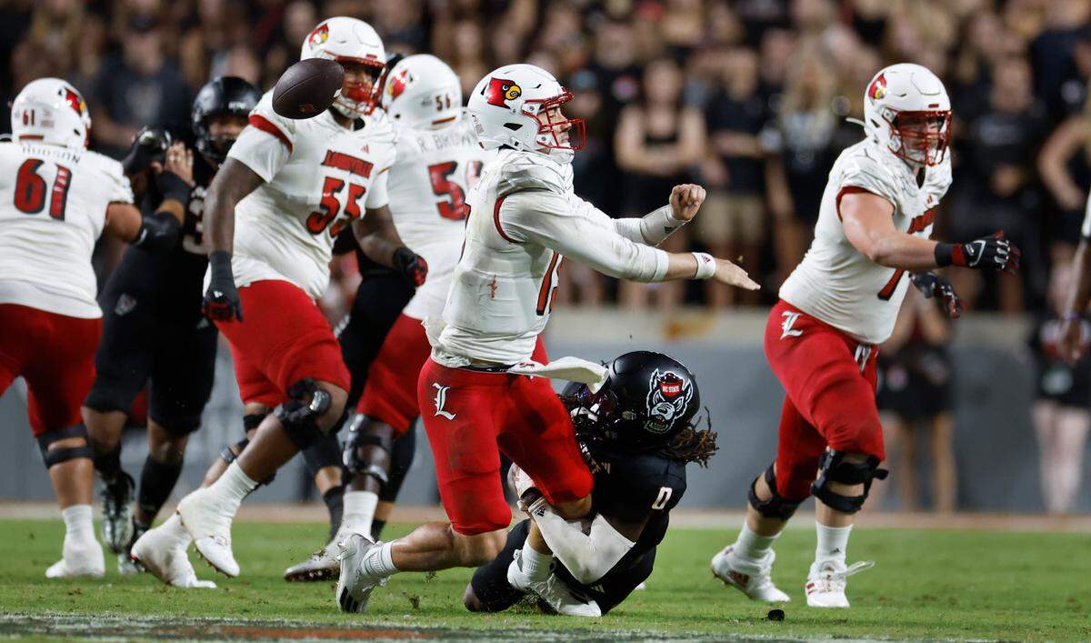 N.C. State safety Sean Brown (0) hits Louisville quarterback Jack Plummer (13), causing him to fumble during the first half of N.C. State’s game against Louisville at Carter-Finley Stadium in Raleigh, N.C., Friday, Sept. 29, 2023.