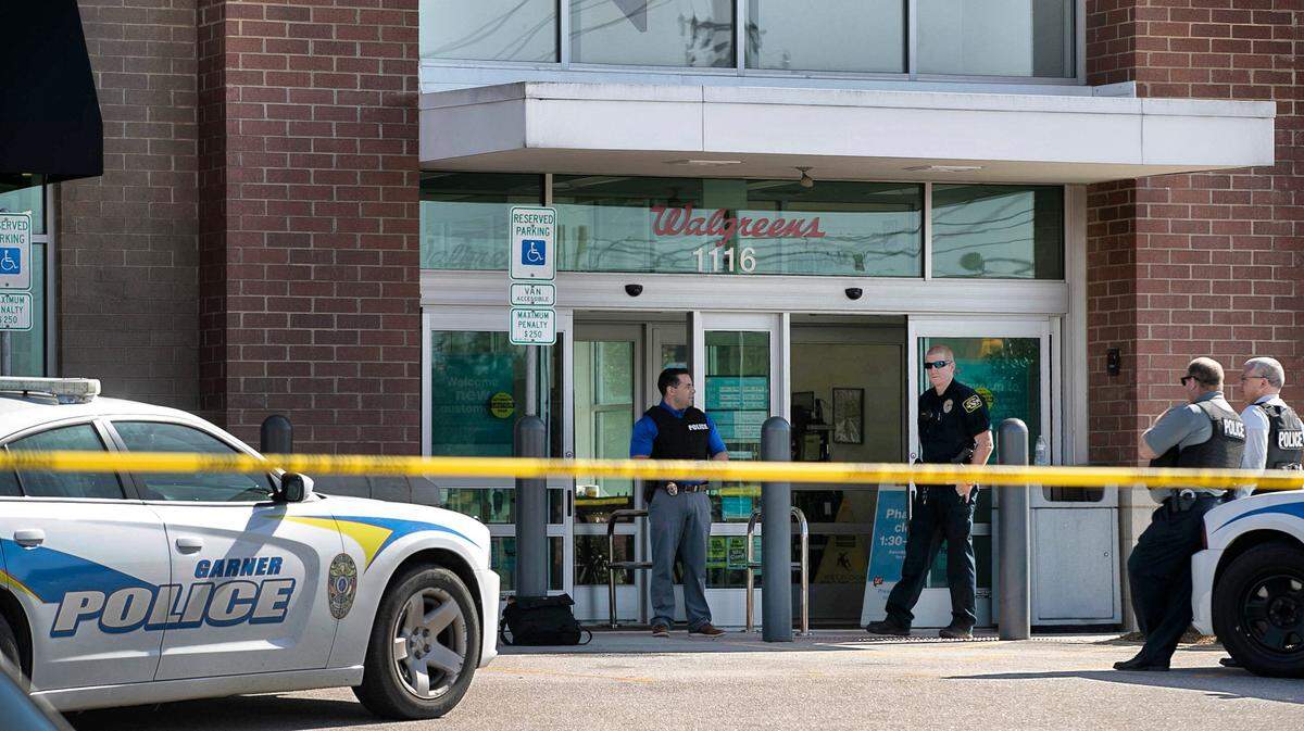 Garner Police stand watch outside the Walgreens on US 70 after two people were shot inside the store on Thursday, February 14, 2019.