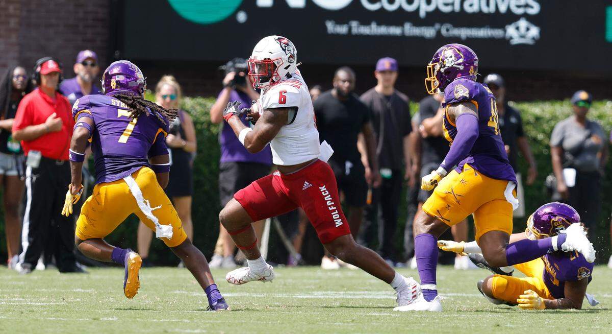 N.C. State tight end Trent Pennix (6) tries to avoid East Carolina safety Gerard Stringer (7) and linebacker Chance Bates (40) during the first half of N.C. State’s game against ECU at Dowdy-Ficklen Stadium in Greenville, N.C., Saturday, Sept. 3, 2022.