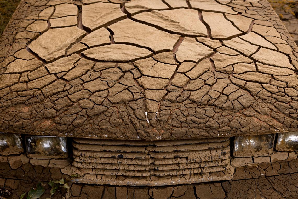 A vehicle flooded by the Pigeon River in the wake of Hurricane Helene is covered with a thick layer of mud at 3610 Broad Street in Clyde, N.C., photographed on Wednesday, Oct. 16, 2024. The river crested at 27.6 feet, damaging almost every home on Broad Street