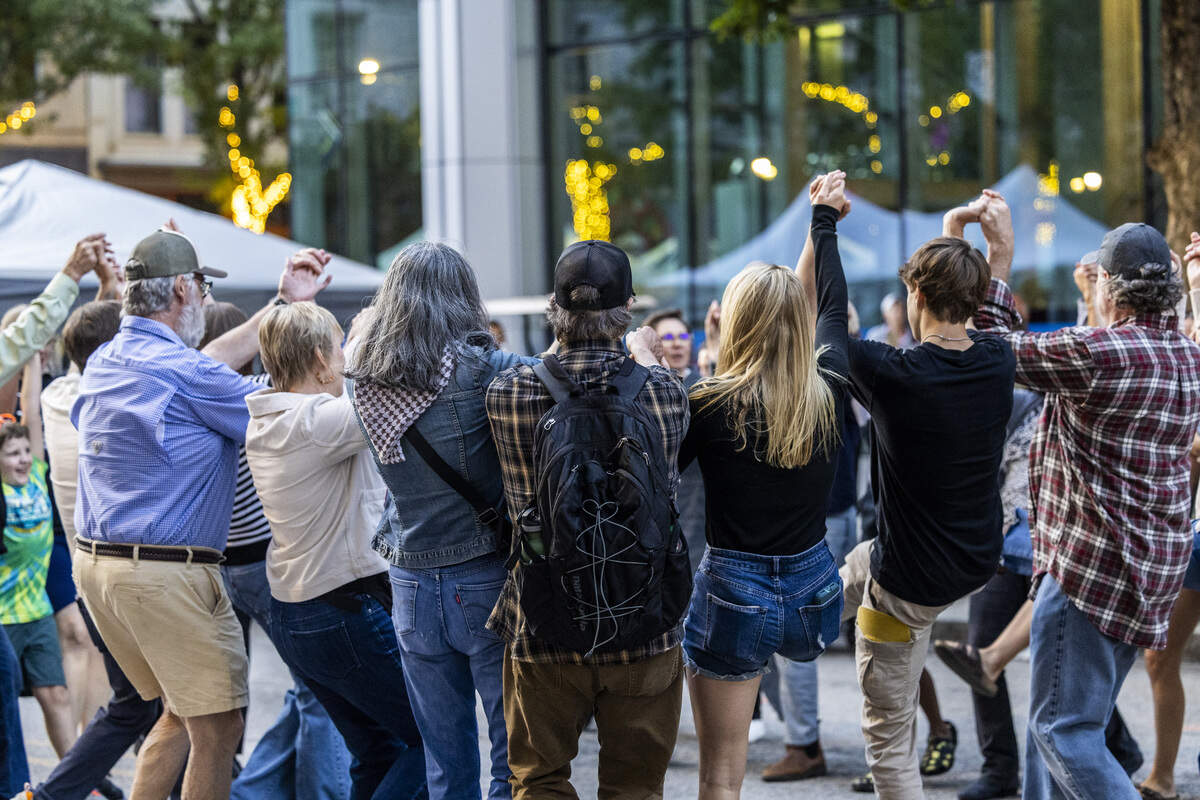 Festival-goers square dance on Martin Street during the Raleigh Wide Open music festival in downtown Raleigh on Friday, Oct. 3, 2025. The event features live bluegrass, folk, Americana and gospel artists.
