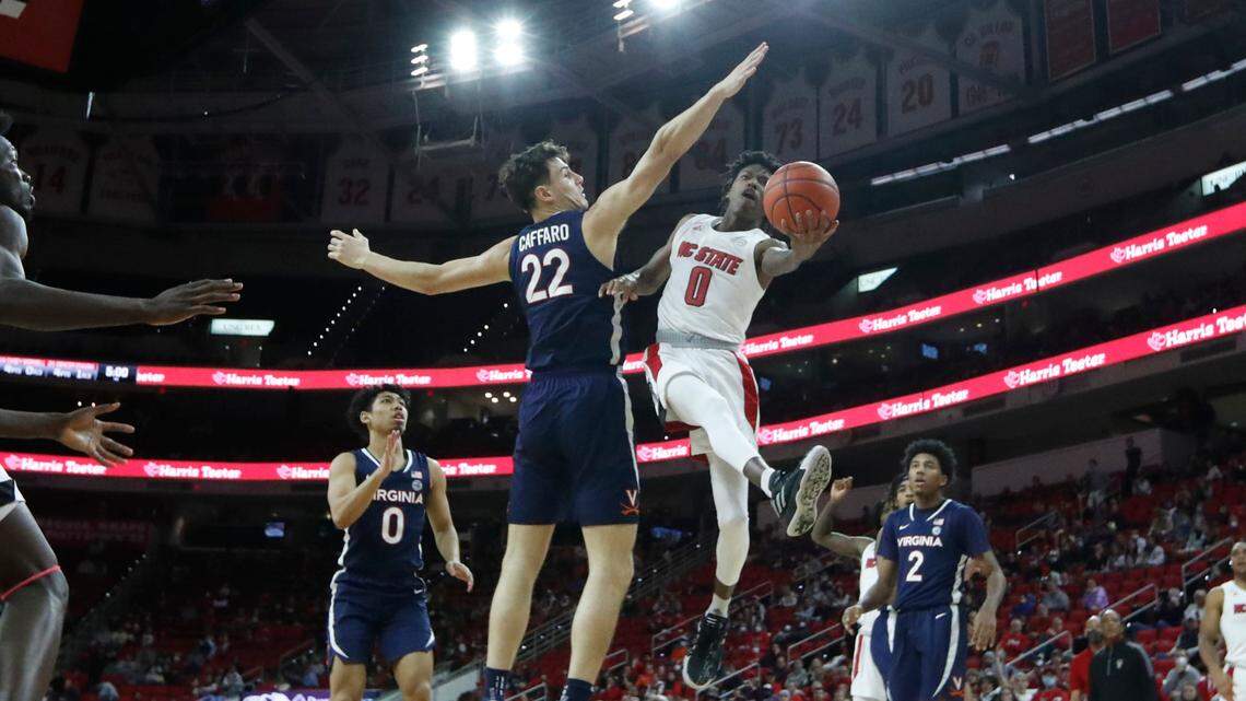 N.C. State’s Terquavion Smith (0) heads to the basket as Virginia’s Francisco Caffaro (22) defends during the second half of N.C. State’s 77-63 victory over Virginia at PNC Arena in Raleigh, N.C., Saturday, Jan. 22, 2022.
