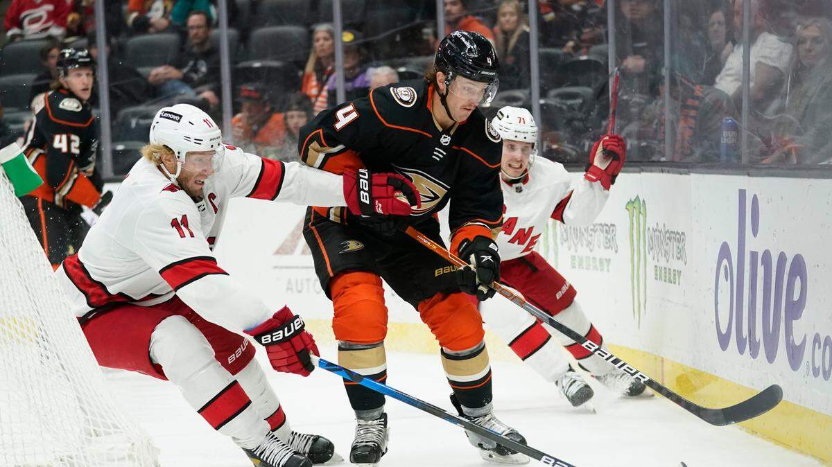 Carolina Hurricanes center Jordan Staal (11) and right wing Jesper Fast (71) defend against Anaheim Ducks defenseman Cam Fowler (4) during the first period of an NHL hockey game in Anaheim, Calif., Thursday, Nov. 18, 2021. (AP Photo/Ashley Landis)
