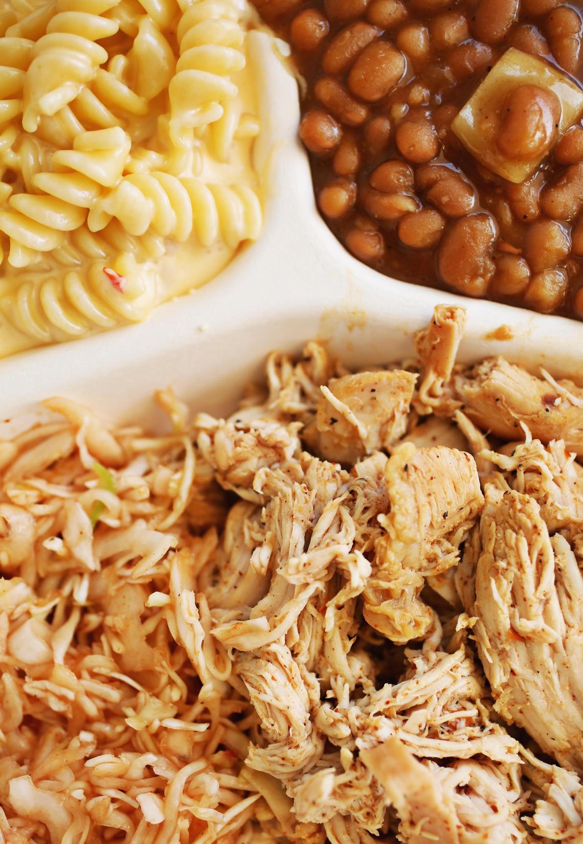 You can get a plate with exceptionally juicy pulled chicken, a slaw of your choice and two sides at Daddy Bob’s Barbecue. Shown here are the mac and cheese, a rich, creamy blend of rotini and three cheeses, and baked beans which are simmered beneath the pork as it cooks in the barbecue smoker.