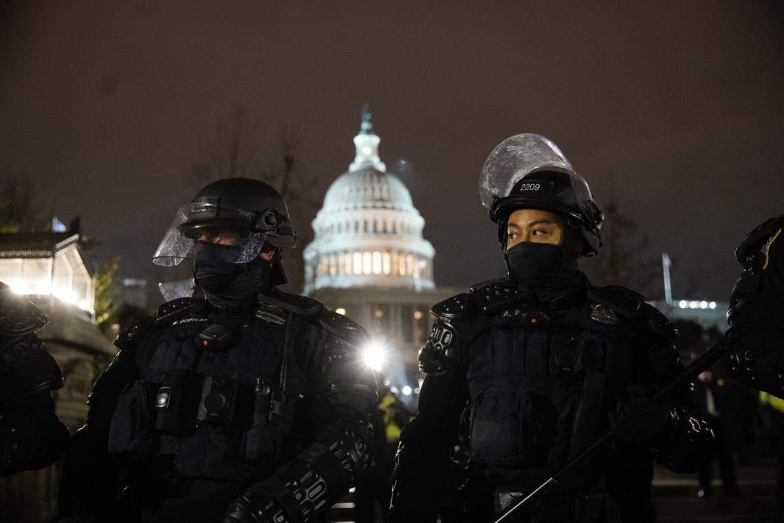Police in riot gear work to help clear streets around the Capitol Wednesday night, Jan. 6, 2021.