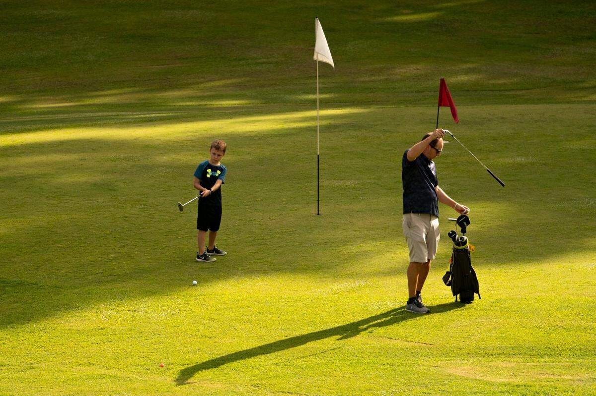 Ethan, 8, and Dan Leeman practice golf together at 401 Par Golf in Raleigh, N.C. on Thursday, Aug. 18, 2022. Developers are planning to buy the 72 acres that 401 Par Golf sits on and build a master-planned residential and commercial community