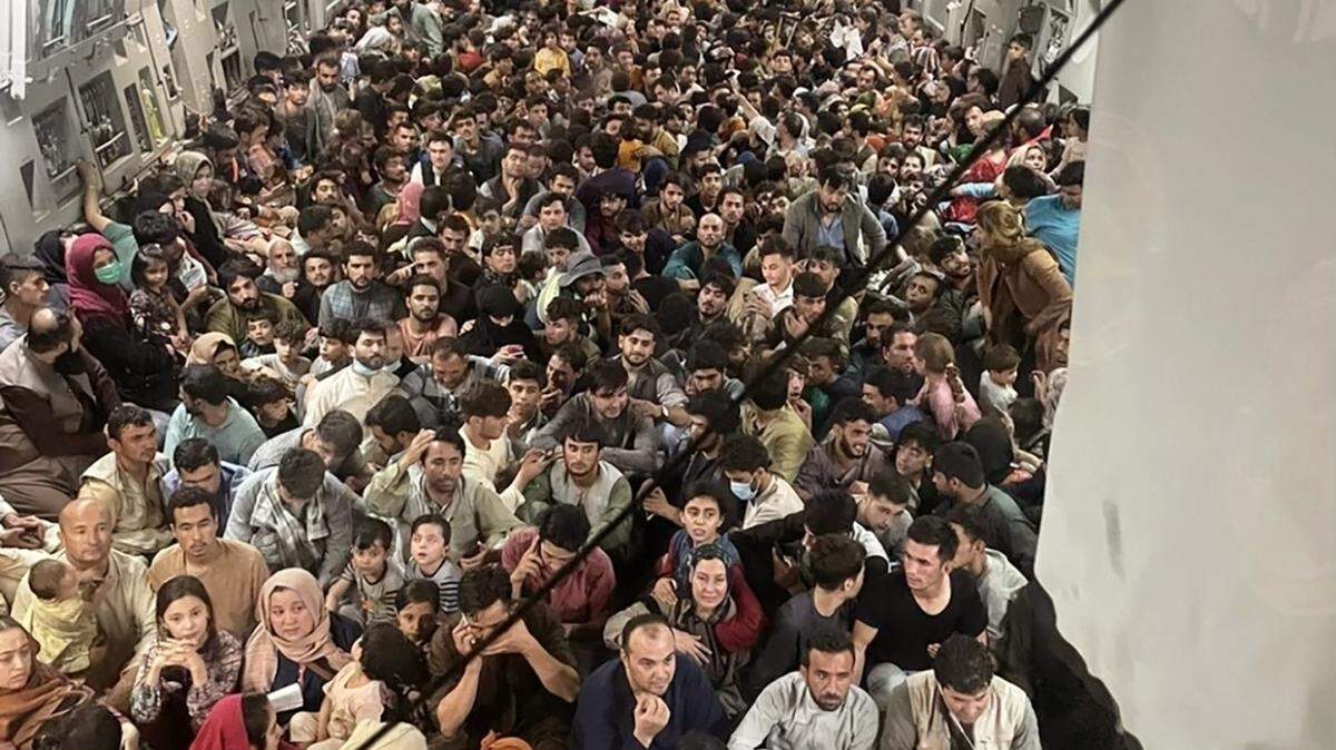 Afghan citizens pack inside a U.S. Air Force C-17 Globemaster III, as they are transported from Hamid Karzai International Airport in Afghanistan, Sunday, Aug. 15, 2021.