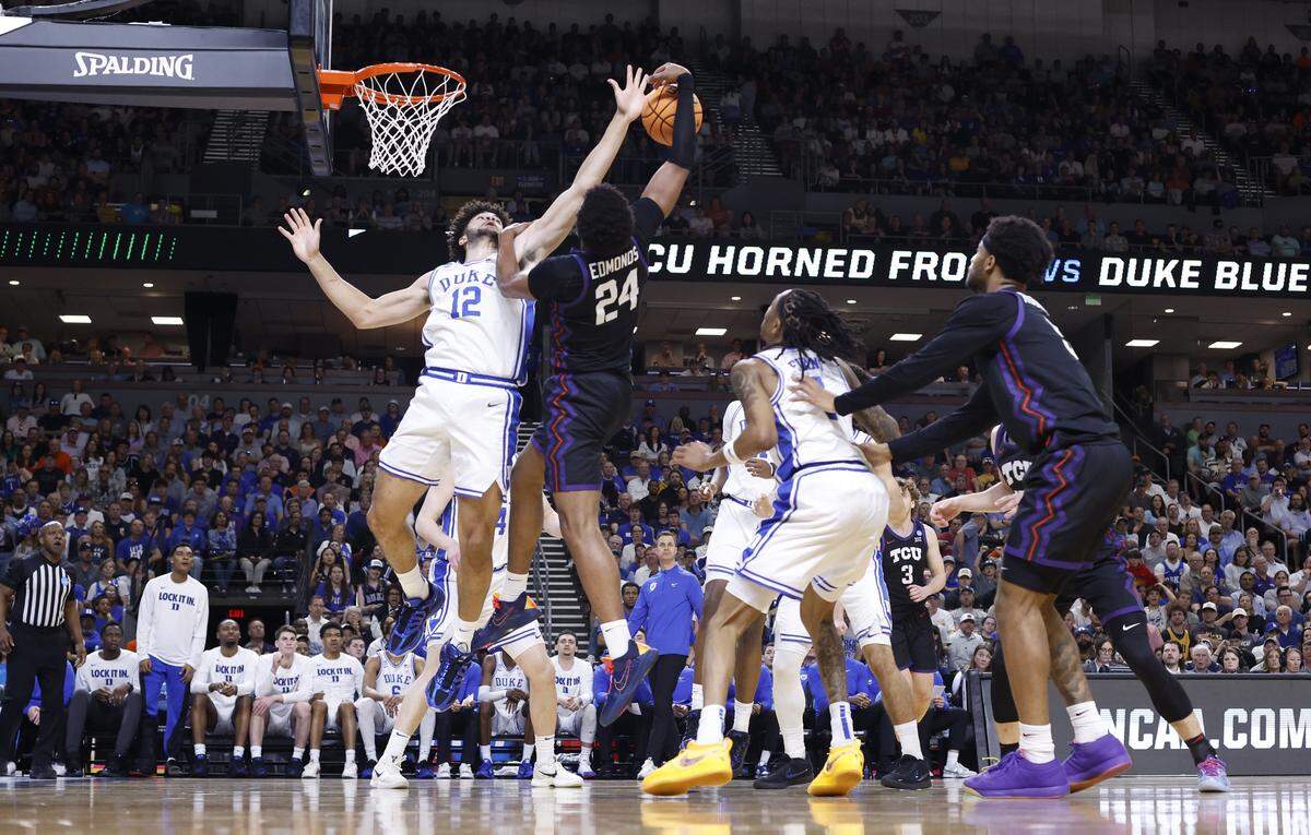 Duke’s Cameron Boozer (12) keeps the ball from TCU’s Xavier Edmonds (24) during Duke’s 81-58 victory over TCU in the second round of the NCAA Men’s Basketball Tournament at  Bon Secours Wellness Arena in Greenville, S.C., Saturday, March 21, 2026.
