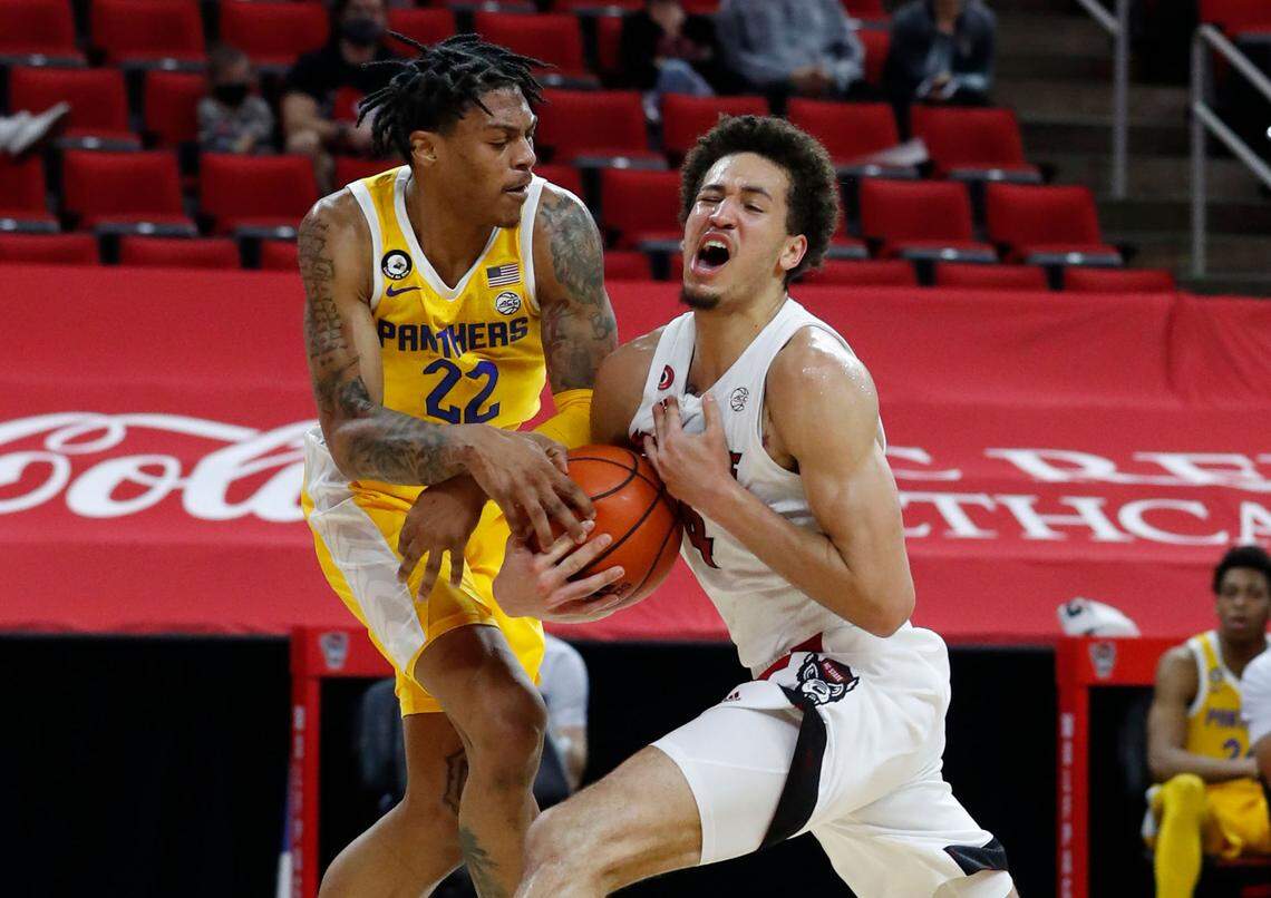 Pittsburgh’s Nike Sibande (22) fouls N.C. State’s Jericole Hellems (4) during the first half of N.C. State’s game against Pittsburgh at PNC Arena in Raleigh, N.C., Sunday, February 28, 2021.