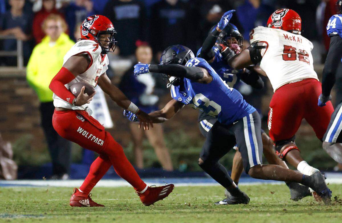 N.C. State quarterback MJ Morris (7) tries to escape from Duke safety Terry Moore (23) during the second half of Duke’s 24-3 victory over N.C. State at Wallace Wade Stadium in Durham, N.C., Saturday, Oct. 14, 2023.